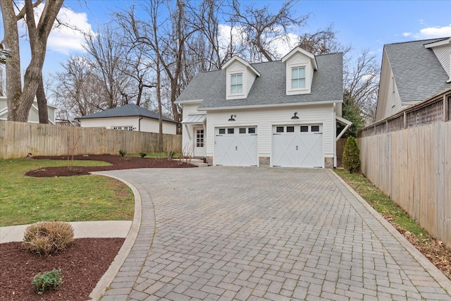 garage with fence and decorative driveway