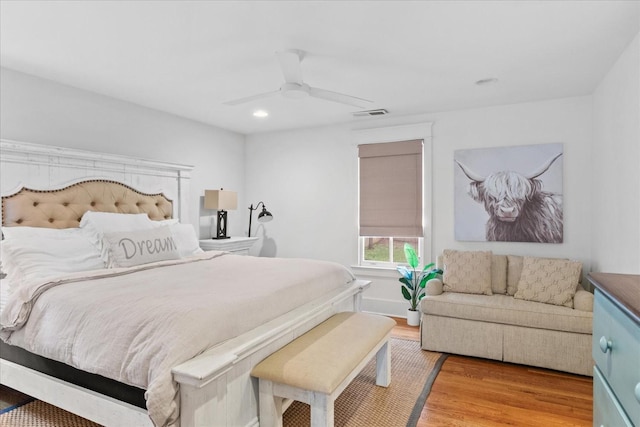 bedroom featuring a ceiling fan, visible vents, and wood finished floors