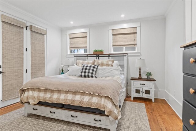 bedroom featuring crown molding, baseboards, wood finished floors, and recessed lighting