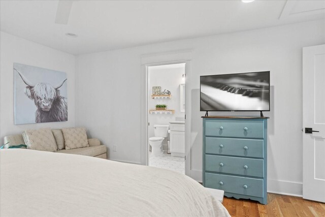 bedroom featuring connected bathroom and light wood-style flooring