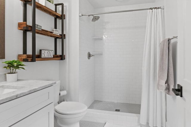 bathroom with toilet, a stall shower, and vanity