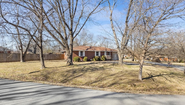 single story home with fence, a front lawn, and brick siding