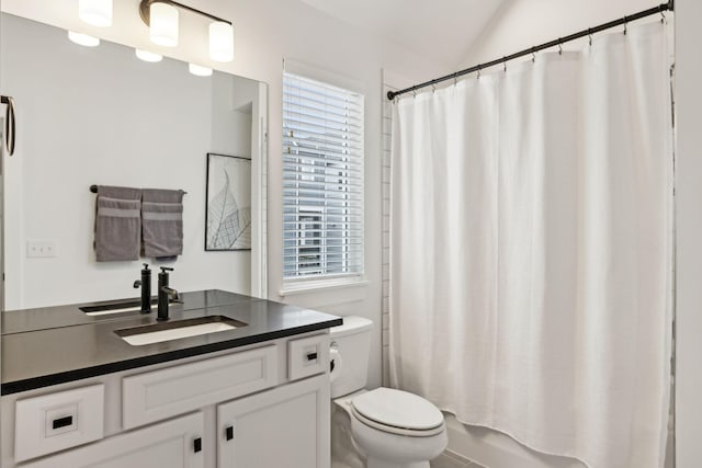 full bath featuring lofted ceiling, shower / bathtub combination with curtain, vanity, and toilet