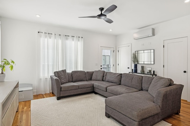 living area with recessed lighting, ceiling fan, light wood finished floors, and a wall mounted AC