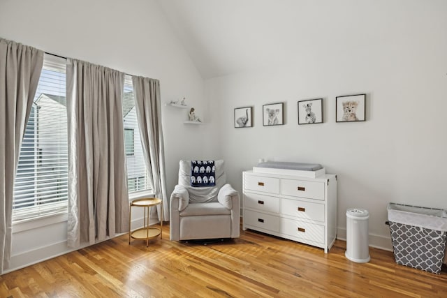 unfurnished room featuring a healthy amount of sunlight, light wood-style flooring, baseboards, and lofted ceiling