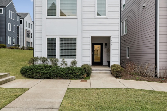 property entrance with a lawn