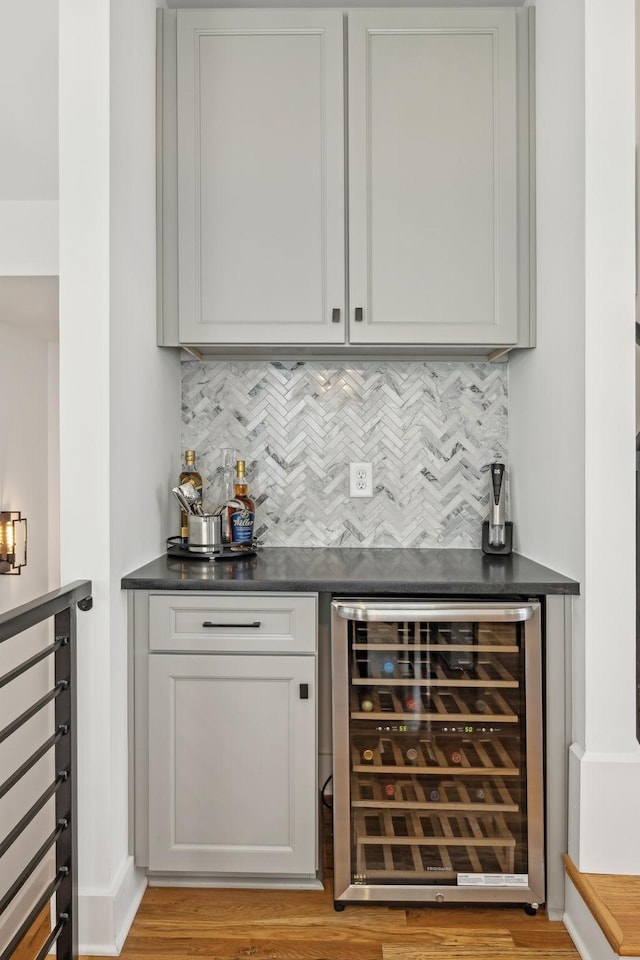 bar with a dry bar, beverage cooler, and backsplash