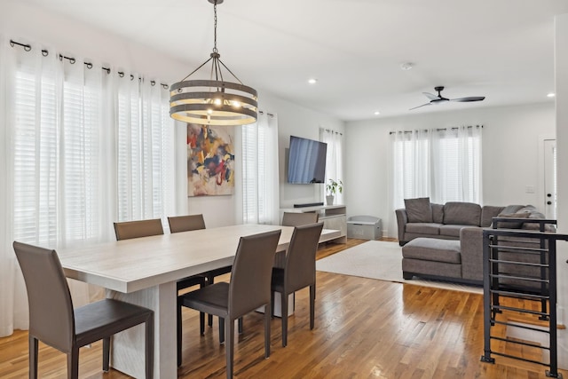 dining space featuring ceiling fan with notable chandelier, light wood-type flooring, and recessed lighting