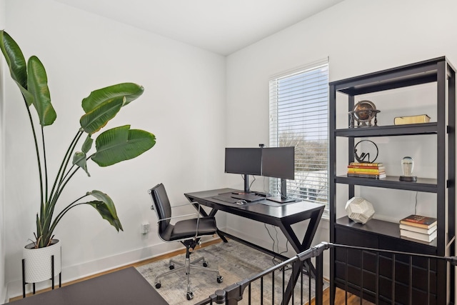 office space with plenty of natural light, baseboards, and wood finished floors