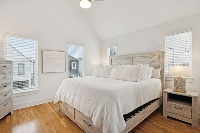 bedroom with multiple windows, wood finished floors, and baseboards