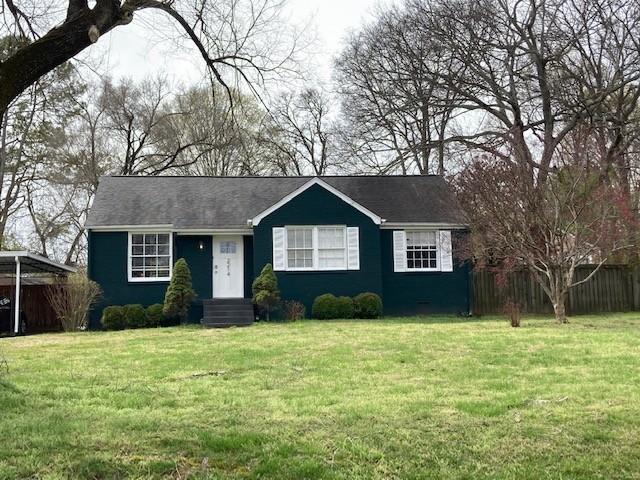 view of front of house with a front lawn and fence