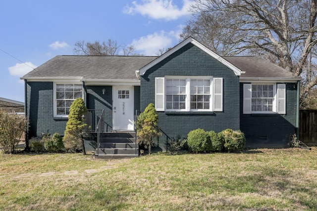 view of front of home featuring a shingled roof, a front yard, brick siding, and crawl space