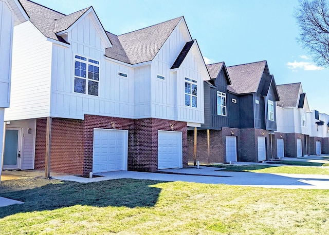 view of front facade featuring a garage, a front lawn, board and batten siding, and brick siding