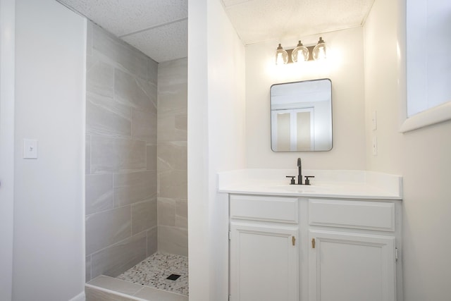 full bath featuring a tile shower and vanity