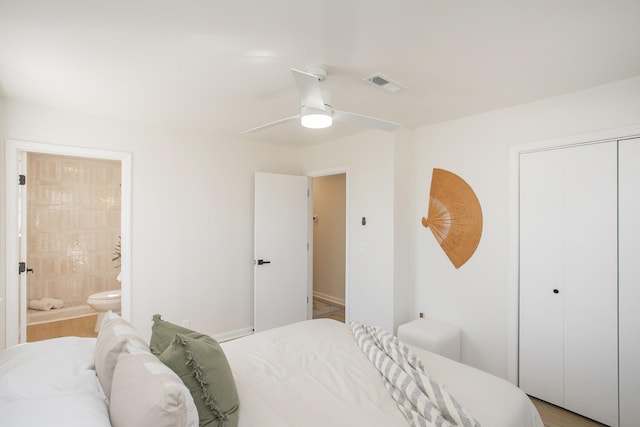 bedroom with a ceiling fan, a closet, visible vents, and ensuite bath