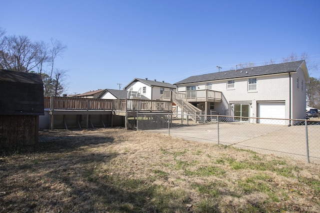 rear view of property with driveway, stairs, fence, and a deck