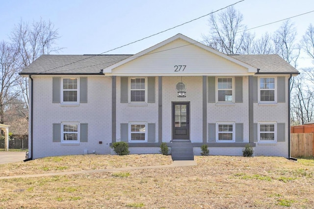 raised ranch with brick siding and fence