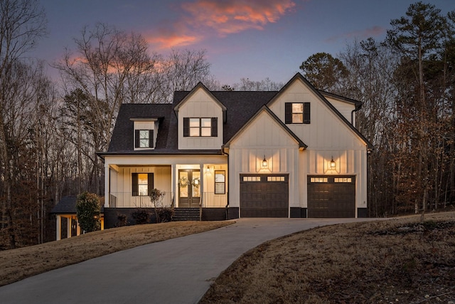 modern farmhouse featuring driveway, covered porch, board and batten siding, and roof with shingles