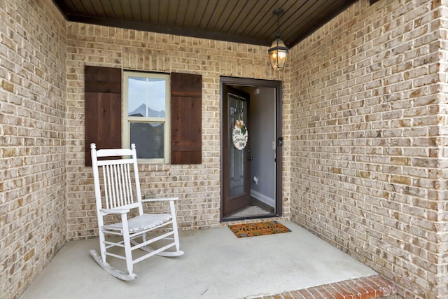 view of exterior entry featuring brick siding