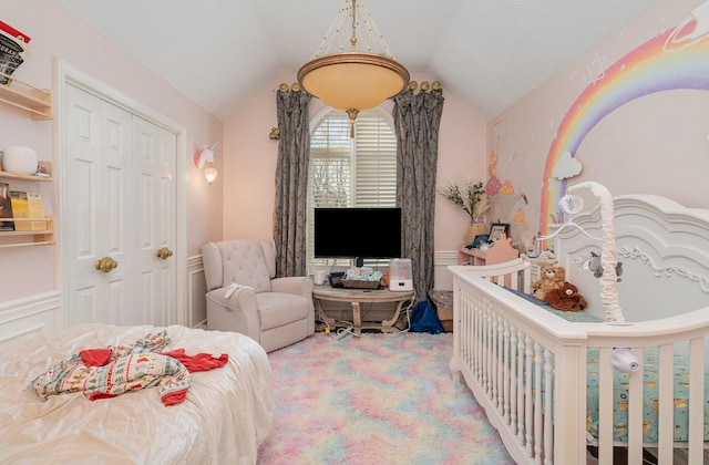 carpeted bedroom with a closet and vaulted ceiling