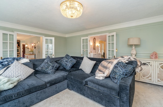 living room with an inviting chandelier, carpet, crown molding, and french doors