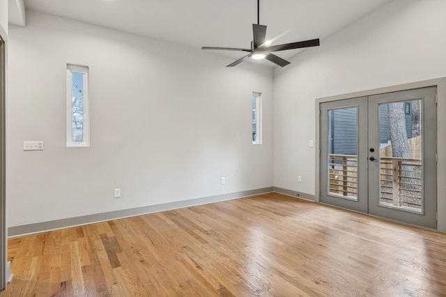 empty room with a ceiling fan, french doors, light wood-style flooring, and baseboards