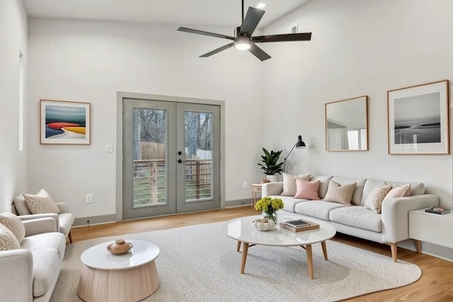 living room featuring a ceiling fan, french doors, baseboards, and wood finished floors