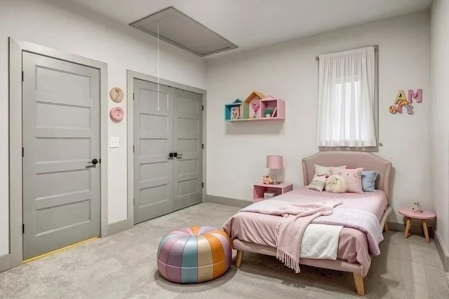 carpeted bedroom with attic access and baseboards