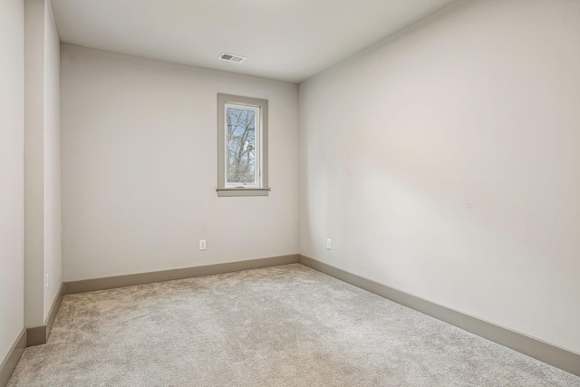 spare room with carpet, visible vents, and baseboards