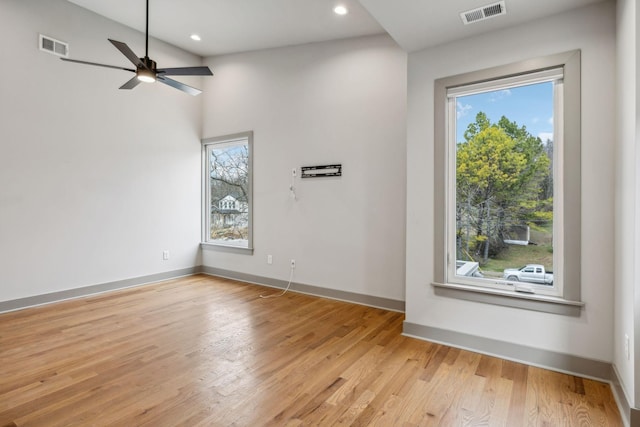 unfurnished room featuring light wood-style flooring, visible vents, and a wealth of natural light