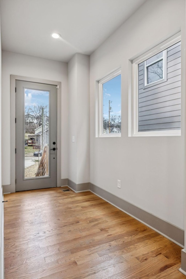 doorway with light wood-style floors, a wealth of natural light, baseboards, and recessed lighting