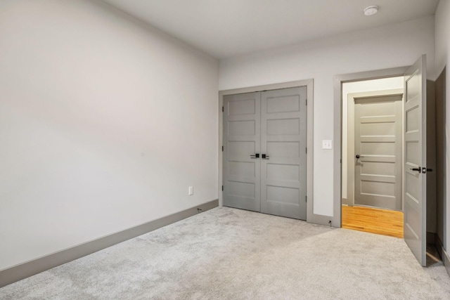 unfurnished bedroom with a closet, carpet flooring, and baseboards