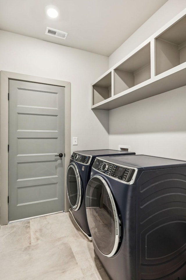 clothes washing area with laundry area, visible vents, and independent washer and dryer