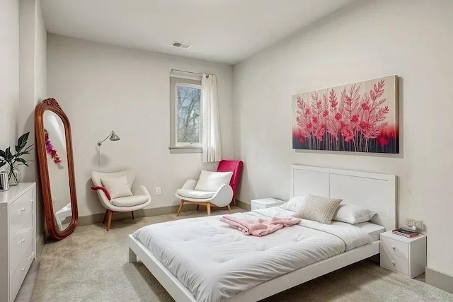 bedroom featuring baseboards, visible vents, and light colored carpet