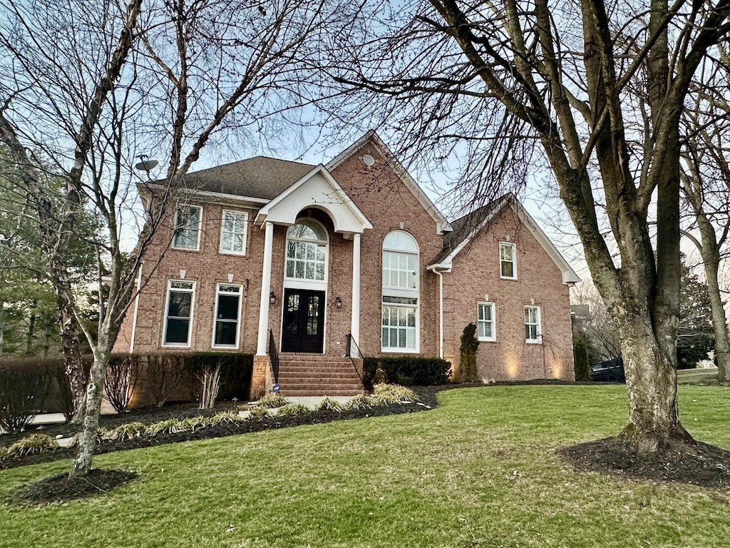 view of front facade with a front yard and brick siding