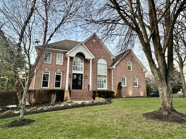 view of front facade with a front yard and brick siding