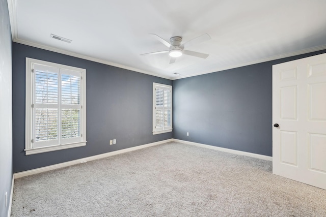 carpeted empty room featuring visible vents, baseboards, ceiling fan, and crown molding