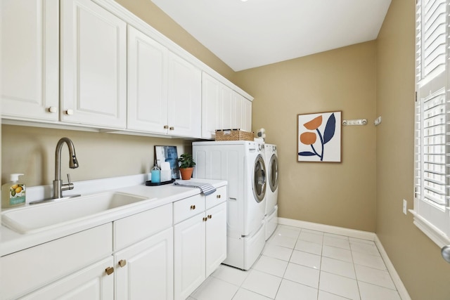 washroom featuring washing machine and clothes dryer, cabinet space, baseboards, and a sink