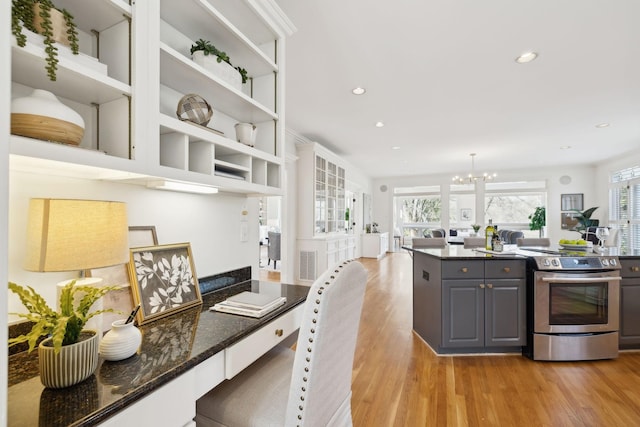 kitchen with an inviting chandelier, light wood-style flooring, stainless steel electric stove, and gray cabinetry
