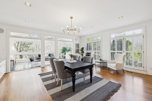 dining room featuring light wood finished floors, recessed lighting, an inviting chandelier, and ornamental molding