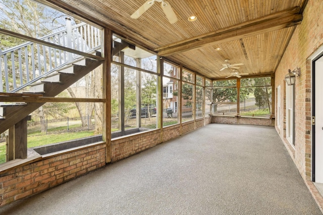 unfurnished sunroom featuring beam ceiling, wooden ceiling, and ceiling fan