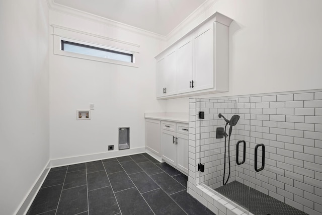 washroom with dark tile patterned flooring, washer hookup, baseboards, ornamental molding, and cabinet space