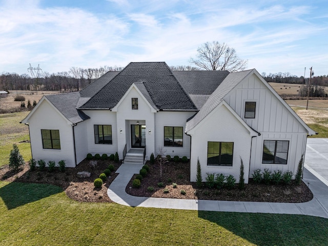 modern farmhouse style home with a front lawn, board and batten siding, and a shingled roof