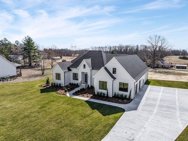 modern farmhouse style home featuring concrete driveway, a shingled roof, board and batten siding, and a front yard