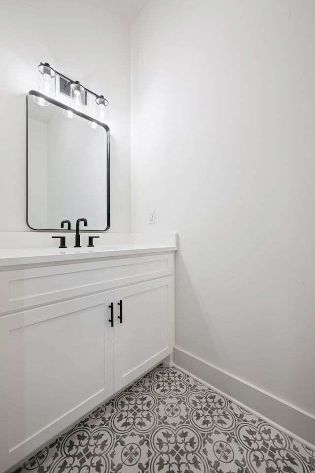 bathroom with vanity, baseboards, and tile patterned floors