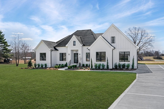 modern farmhouse style home featuring board and batten siding and a front lawn