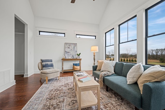 living area with dark wood-type flooring, visible vents, and plenty of natural light