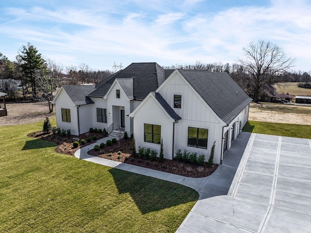 view of front of property with driveway, a shingled roof, a front lawn, and board and batten siding