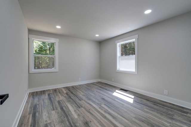 unfurnished room featuring recessed lighting, wood finished floors, visible vents, and baseboards