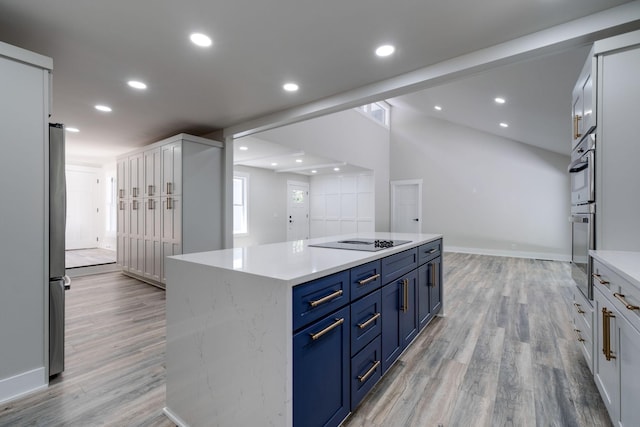 kitchen featuring stainless steel appliances, recessed lighting, light wood-style flooring, a kitchen island, and blue cabinets